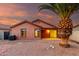 The backyard features gravel, a palm tree, a block fence, and a covered patio at 8433 E Natal Cir, Mesa, AZ 85209