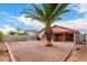 The backyard features gravel, a palm tree, a block fence and a covered patio at 8433 E Natal Cir, Mesa, AZ 85209
