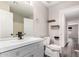 This bathroom features tile floors, a sink with a mirror, toilet, and two shelves at 8433 E Natal Cir, Mesa, AZ 85209