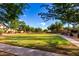 Expansive green space with walking path, mature trees and landscaping, and comfortable seating for residents to enjoy at 8433 E Natal Cir, Mesa, AZ 85209