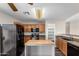 A well-lit kitchen featuring oak cabinets, black appliances, granite counters, and an island at 8433 E Natal Cir, Mesa, AZ 85209