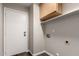 This laundry room features a door, upper cabinets, a shelf, and washer dryer hookups at 8433 E Natal Cir, Mesa, AZ 85209