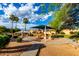 Community playground featuring covered play structures, picnic tables, and lush landscaping under a bright sky at 8433 E Natal Cir, Mesa, AZ 85209