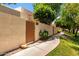 Home exterior with a private entry gate, block wall, and sidewalk lined with mature landscaping at 8818 N 47Th Ln, Glendale, AZ 85302