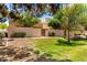 Inviting exterior of a home featuring a secure walled patio, grassy area, and mature trees at 8818 N 47Th Ln, Glendale, AZ 85302