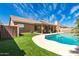Backyard view with pool, artificial grass, covered patio, and tiled roof under a blue sky at 901 N Quartz St, Gilbert, AZ 85234