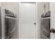 Laundry room featuring matching high-efficiency washer and dryer sets on either side of an interior door at 901 N Quartz St, Gilbert, AZ 85234