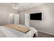 A spacious bedroom featuring a modern light fixture, a TV, and neutral colors at 901 N Quartz St, Gilbert, AZ 85234