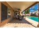 Inviting covered patio with stylish furniture, overlooking a refreshing pool and landscaped backyard at 901 N Quartz St, Gilbert, AZ 85234