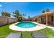 Backyard pool featuring artificial grass, palm trees, and patio furniture under a covered area at 901 N Quartz St, Gilbert, AZ 85234