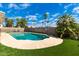 Backyard showcasing a pristine pool, surrounded by artificial turf, palm trees, and a block fence at 901 N Quartz St, Gilbert, AZ 85234