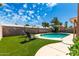 Backyard featuring a private pool surrounded by artificial turf and a block wall for privacy at 901 N Quartz St, Gilbert, AZ 85234