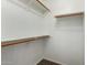 A simple, white walk-in closet with wood shelving, offering ample storage space at 901 N Quartz St, Gilbert, AZ 85234