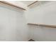 A simple, white walk-in closet with wood shelving for organized storage at 901 N Quartz St, Gilbert, AZ 85234
