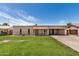 Charming single-story home with a well-manicured lawn and light brickwork against a bright blue sky at 908 S Kachina --, Mesa, AZ 85204