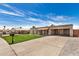 Street view of a single-story home with light brick and an open carport, set against a blue sky at 908 S Kachina --, Mesa, AZ 85204