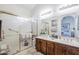 Main bathroom with dual sinks, warm wood vanity, and separate glass shower enclosure, providing luxury at 9705 E Mountain View Rd # 1096, Scottsdale, AZ 85258