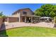 Expansive backyard featuring a covered patio, outdoor decor, and lush green grass at 991 N Quail Ln, Gilbert, AZ 85233