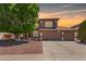 Charming two-story home featuring a tile roof, three-car garage, desert landscaping, and mature shade tree at 991 N Quail Ln, Gilbert, AZ 85233