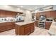 Open concept kitchen featuring dark wood cabinets, stainless steel appliances, and center island at 991 N Quail Ln, Gilbert, AZ 85233