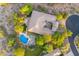 An aerial shot displaying the home's backyard oasis with a large pool, mature trees, and patio at 10694 E Redfield Rd, Scottsdale, AZ 85255