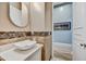 Half bath with vessel sink, decorative tile accents, and an entryway to another room at 10694 E Redfield Rd, Scottsdale, AZ 85255