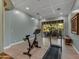 Brightly lit gym with workout bike and treadmill leading to an outdoor patio overlooking trees at 10694 E Redfield Rd, Scottsdale, AZ 85255