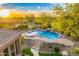 Backyard view highlighting a large pool with a waterfall feature, lush landscaping, and a covered patio at 10694 E Redfield Rd, Scottsdale, AZ 85255
