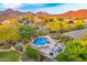 Inviting backyard oasis with a freeform pool, stone waterfall, lush landscaping, and mountain views at 10694 E Redfield Rd, Scottsdale, AZ 85255