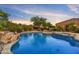 Inviting pool area featuring a waterfall and mature landscaping at 10694 E Redfield Rd, Scottsdale, AZ 85255