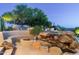 Outdoor patio area includes spa with unique rock features and built in seating for desert backyard at 10822 E Prospect Point Dr, Scottsdale, AZ 85262
