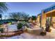Stunning desert home backyard with custom pool, spa, stone patio and lush landscaping at twilight at 10822 E Prospect Point Dr, Scottsdale, AZ 85262