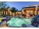 Backyard pool with rock features and lush landscaping at this elegant desert home at 10822 E Prospect Point Dr, Scottsdale, AZ 85262