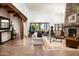 Spacious living room with stone fireplace, wood beams, and access to a patio, perfect for relaxation and entertaining at 10822 E Prospect Point Dr, Scottsdale, AZ 85262