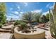 Beautiful backyard featuring a pool with rock features, lounge chairs, and a built-in seating area at 10822 E Prospect Point Dr, Scottsdale, AZ 85262