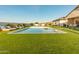 Expansive backyard with a sparkling pool, ample seating, and lush artificial grass, perfect for outdoor living at 10918 W Dove Roost Rd, Queen Creek, AZ 85144