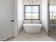 Bright bathroom features a modern tub, glass shower, and black-trimmed window at 10918 W Dove Roost Rd, Queen Creek, AZ 85144