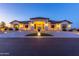 Stunning home exterior showcasing the home's architecture, lighting, and desert landscaping at twilight at 10918 W Dove Roost Rd, Queen Creek, AZ 85144