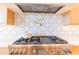 Close-up of the kitchen stove with a pot filler and decorative backsplash at 10918 W Dove Roost Rd, Queen Creek, AZ 85144