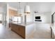 Bright kitchen island flows into living space with TV and fireplace at 10918 W Dove Roost Rd, Queen Creek, AZ 85144