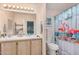 Well-lit bathroom with dual sinks, white tiled countertop, and a decorative shower curtain at 11596 W Sierra Dawn Blvd # 271, Surprise, AZ 85378