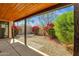 A gravel backyard featuring mature landscaping and covered patio, perfect for outdoor entertaining at 11775 E Becker Ln, Scottsdale, AZ 85259