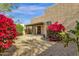 A tranquil backyard featuring vibrant bougainvillea, desert landscaping, and a covered patio area at 11775 E Becker Ln, Scottsdale, AZ 85259