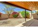 A gravel backyard with lush greenery and a covered patio, offering a private outdoor space at 11775 E Becker Ln, Scottsdale, AZ 85259