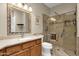 Bathroom featuring a glass shower with a built-in seat and a wood vanity with a framed mirror at 11775 E Becker Ln, Scottsdale, AZ 85259