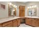 Bathroom with double vanities, wooden cabinets, and stylish mirrors at 11775 E Becker Ln, Scottsdale, AZ 85259