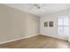 Minimalist bedroom with neutral paint, wood flooring, closet, ceiling fan, and plantation shutters at 11775 E Becker Ln, Scottsdale, AZ 85259