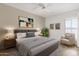 Stylized bedroom with a gray upholstered bed frame, neutral walls, carpet, and bright natural light at 11775 E Becker Ln, Scottsdale, AZ 85259