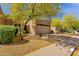 Well-maintained home exterior with desert landscaping, mature trees, and ample parking space at 11775 E Becker Ln, Scottsdale, AZ 85259