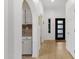 Hallway with wood floors leading to the kitchen with white cabinets and granite countertops at 11775 E Becker Ln, Scottsdale, AZ 85259